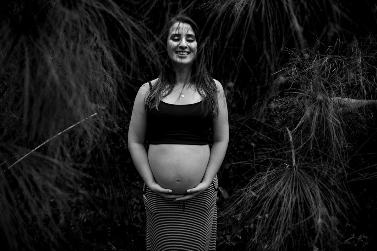 mulher gestante em pé no jardim botânico em são paulo